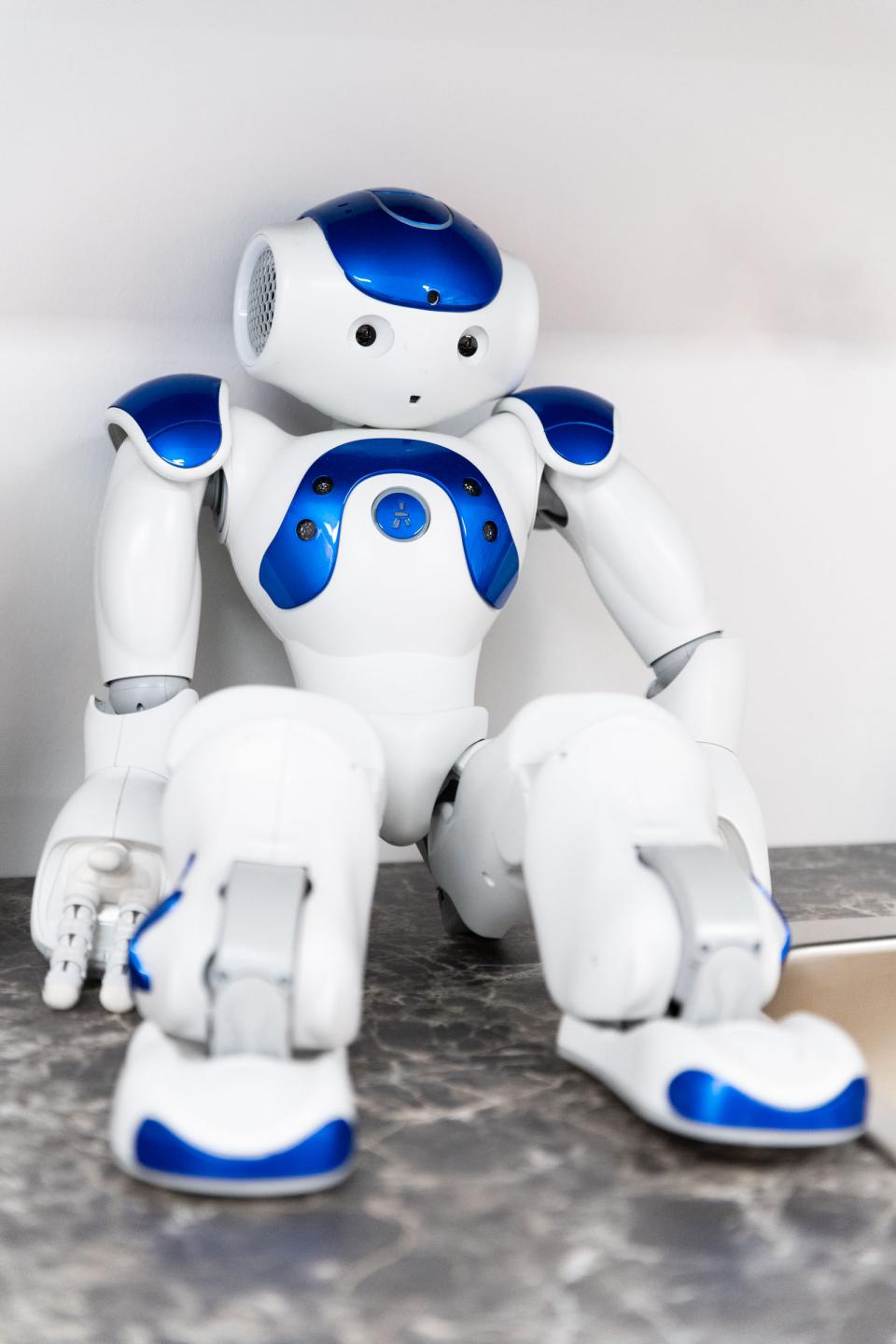 Robotti istuu ja nojaa seinään.